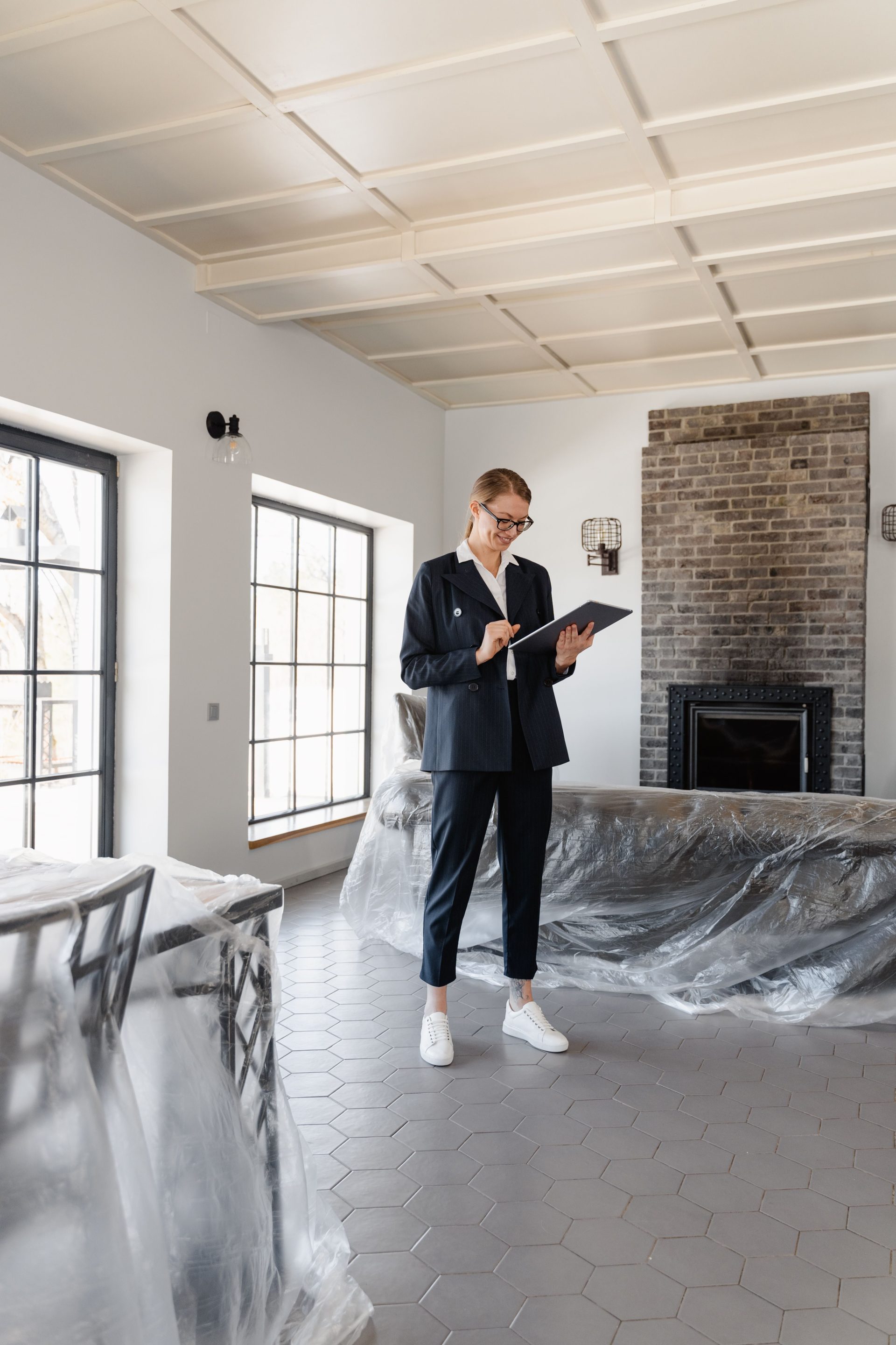Immobilienmakler im Anzug prüft Unterlagen in einem frisch renovierten Haus.